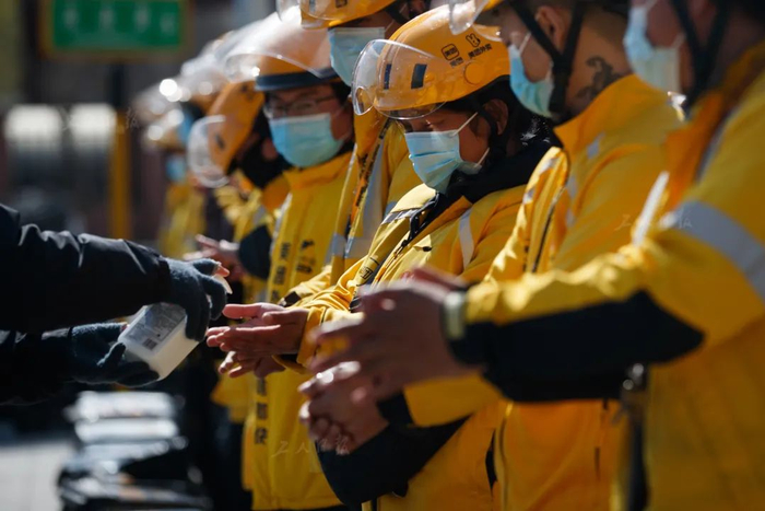 3月31日上午，在开完早会后，美团外卖站点的工作人员正为外卖送餐员双手消毒。