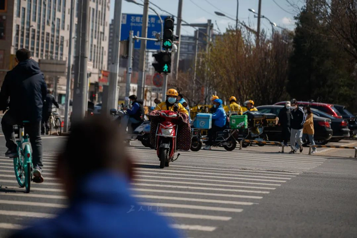 3月31日，宋家庄的街头，宋开清正骑着电动车送外卖。