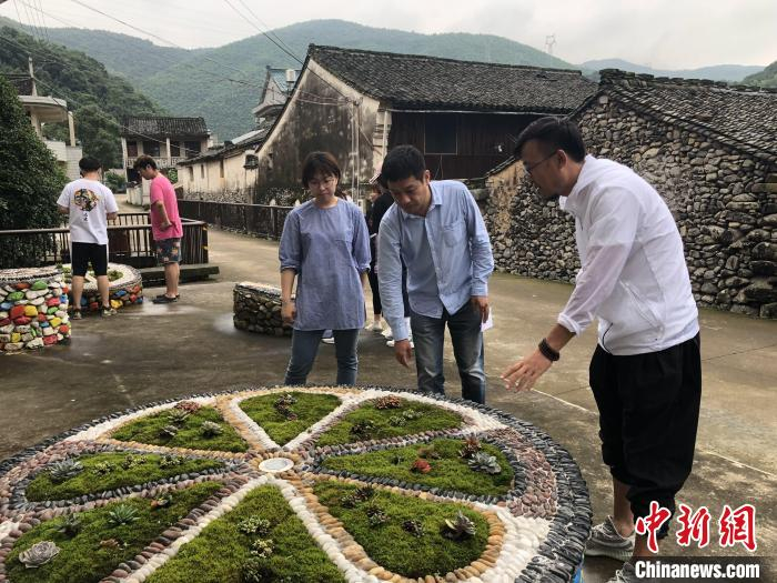 丛志强在向参观者介绍葛家村村民的作品。　宁海县委宣传部供图