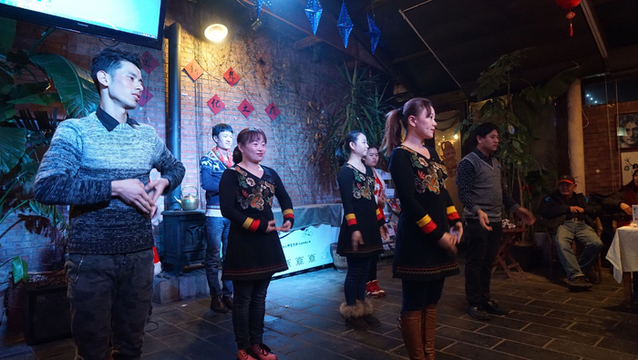 在米娜餐厅举办的跨年活动上，听障员工为大家表演了手语舞蹈，图中第一排中间为芳芳。受访者供图