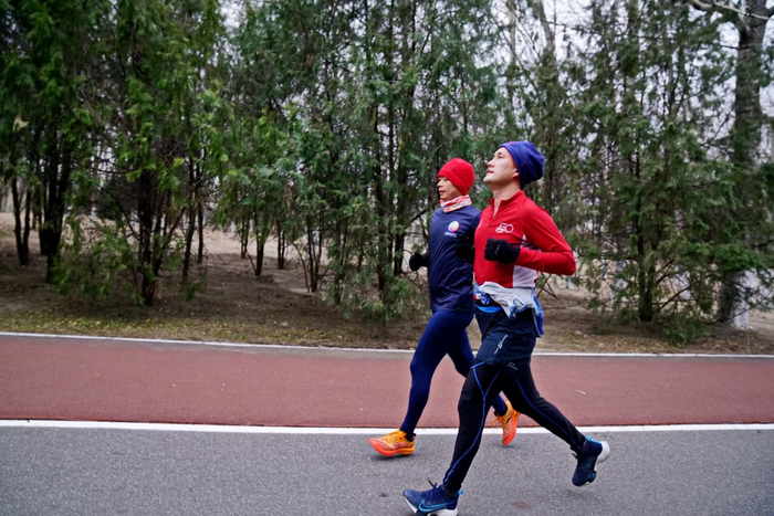 ▲视障者何亚君正在助跑志愿者的陪伴下，在奥林匹克森林公园内晨跑。与郑现伟一样，何亚君也会定期在公园晨跑。受访者供图