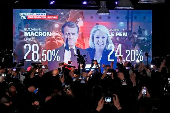一个屏幕显示法国总统埃马纽埃尔·马克龙和极右翼候选人玛丽娜·勒庞在巴黎的选举