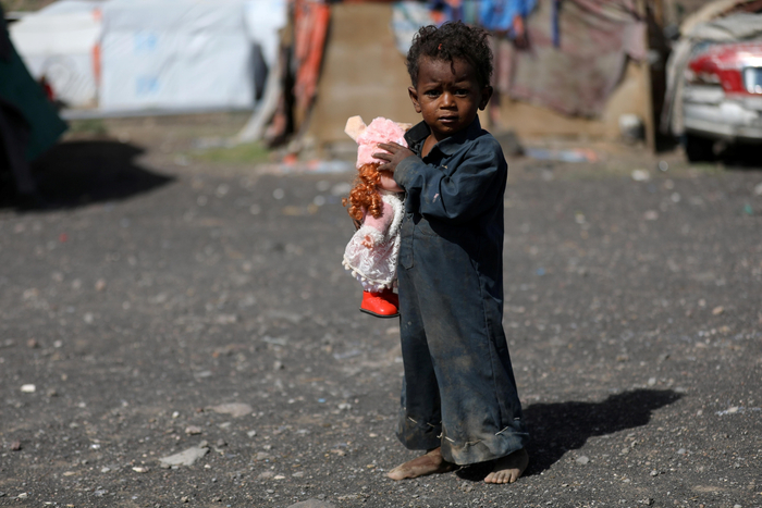 当地时间2022年3月25日，也门萨那一处流离失所者营地里，一个男孩拿着玩具。  图/IC photo