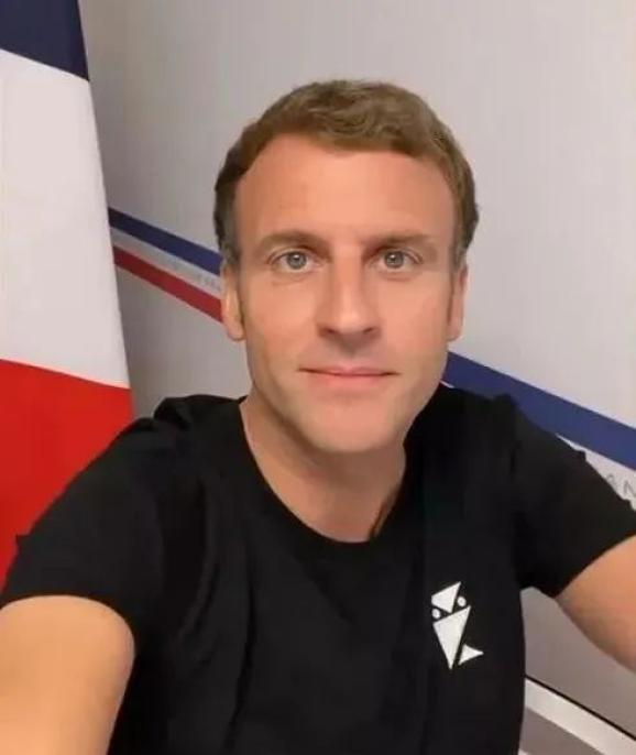 马克龙身穿一件黑色T恤拿着手机自拍