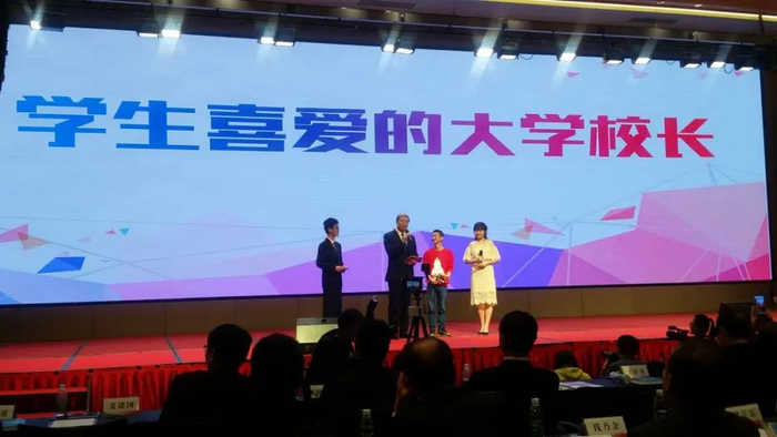 学生代表在颁奖礼上为辛宝忠颁奖（来源：哈尔滨商业大学官网）