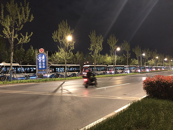 4月16日晚，停靠在锦绣路边的公交车上坐着联勤村村民。本文图片均为澎湃新闻记者 李佳蔚 图