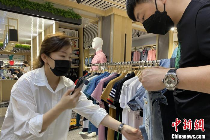 复工后的石狮服装城商户们拍摄产品照片上传给客户。　石狮服装城供图