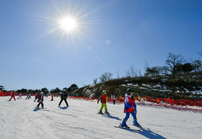 在天津蓟洲国际滑雪场，教练与小朋友在雪道上练习滑雪（2月20日摄）。新华社记者 孙凡越 摄