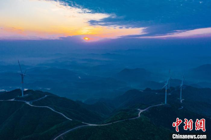 在江西省吉安市峡江县，安静自由的白色风车，像伫立于连绵山脉的守护者，划成一道亮丽的风景线。　李小明 摄