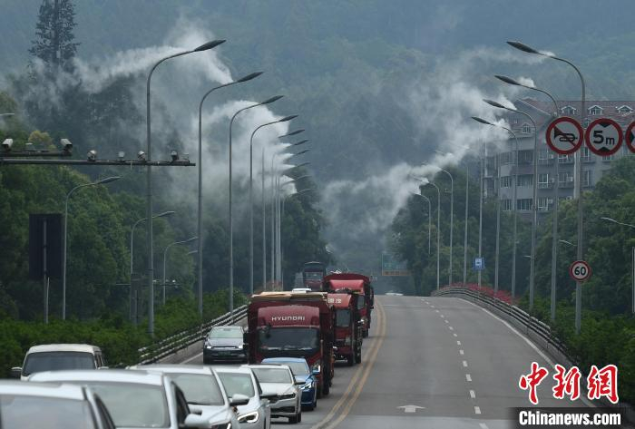 公路两旁的路灯上正喷着水雾。　陈超 摄