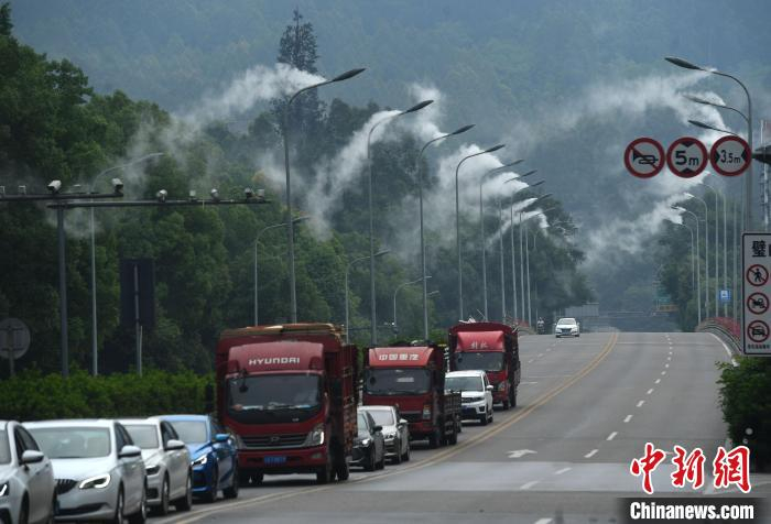 公路两旁的路灯上正喷着水雾。　陈超 摄