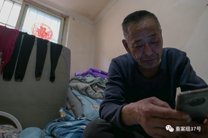 ▲4月12日，午饭过后，吕福林在出租屋里用手机刷短视频打发时间。  新京报实习生 汤赛坤 摄