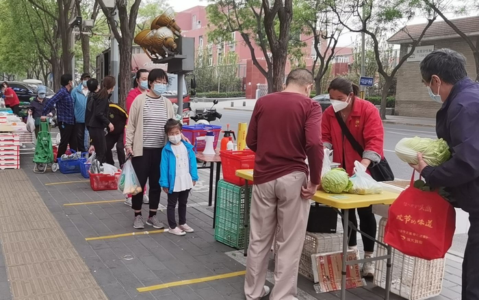 蔬菜直通车按要求在地上贴了一米线，提示居民按一米线排队。受访者供图