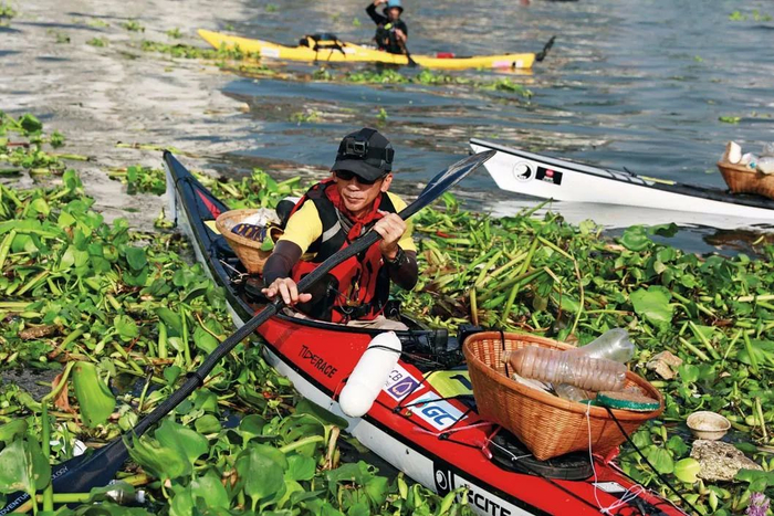 在泰国曼谷的昭披耶河上，志愿者乘坐皮划艇清除河面垃圾