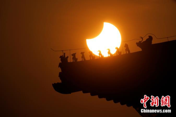 2019年1月6日，日偏食带食而出，从故宫屋檐一角升起。中新社记者  孙自法 摄