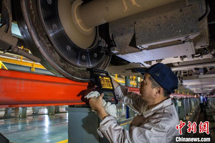 工作人员对高铁车轮进行检查测试。　许然 摄