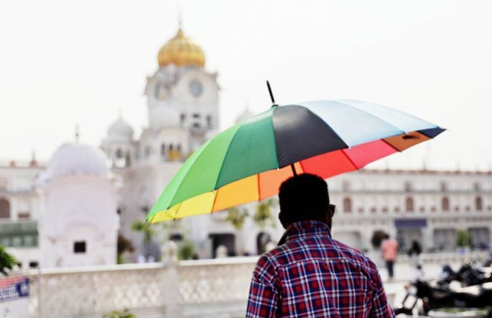 4月29日，在印度阿姆利则，人们用各种办法防晒、降温消暑。（图源：新华社）