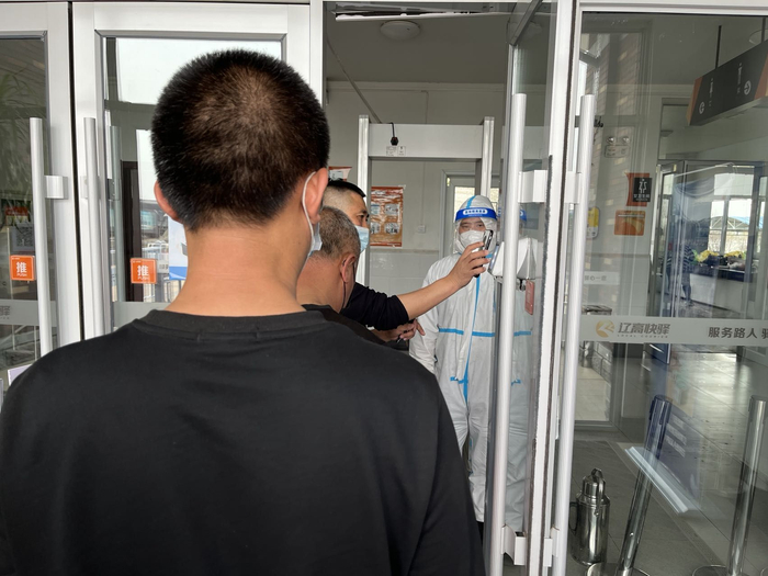 4月21日，开原服务区，卡车司机们排队扫码进入公厕。新京报记者 杜寒三 摄