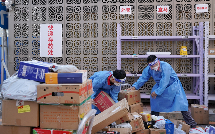 快递员在小区外设立的快递存放处分拣快递。新京报记者 裴剑飞 摄