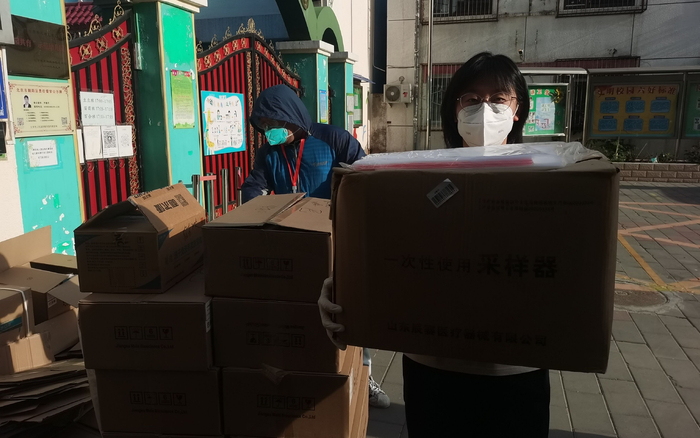 朝阳区劲松街道农光东里社区党委副书记霍炜倩在小区搬运物资。受访者供图