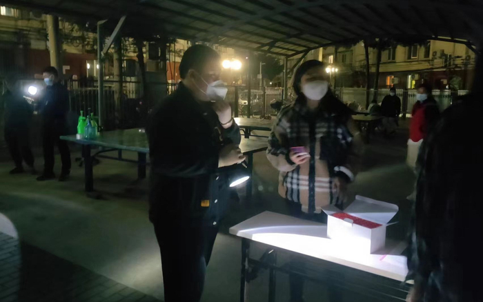 4月26日晚，许天毅在核酸检测点帮助居民登记。受访者供图