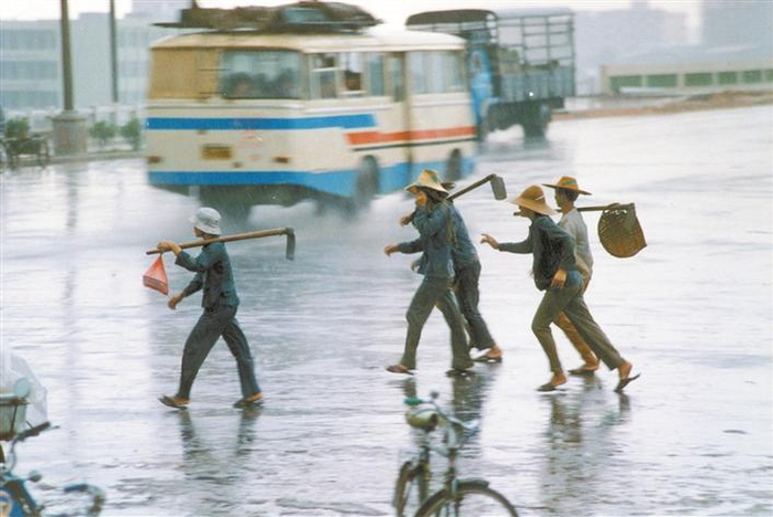 上世纪八十年代初的一个台风天，一批特区建设者顶风冒雨经过罗湖区笋岗桥奔赴建设工地。江式高 摄