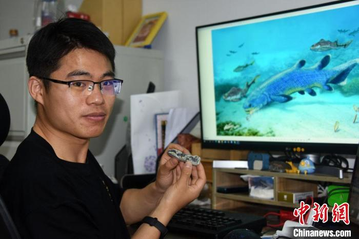 崔心东博士展示介绍杨氏鱼化石标本及研究成果。　中新社记者 孙自法 摄