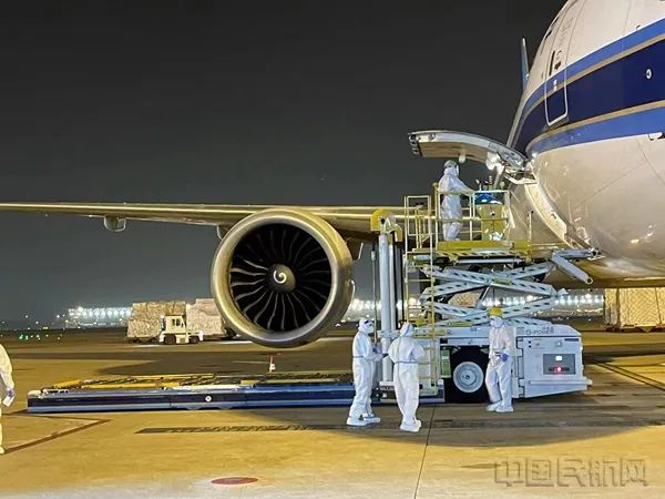 现场工作人员身穿防护服保障货物（南航供图）