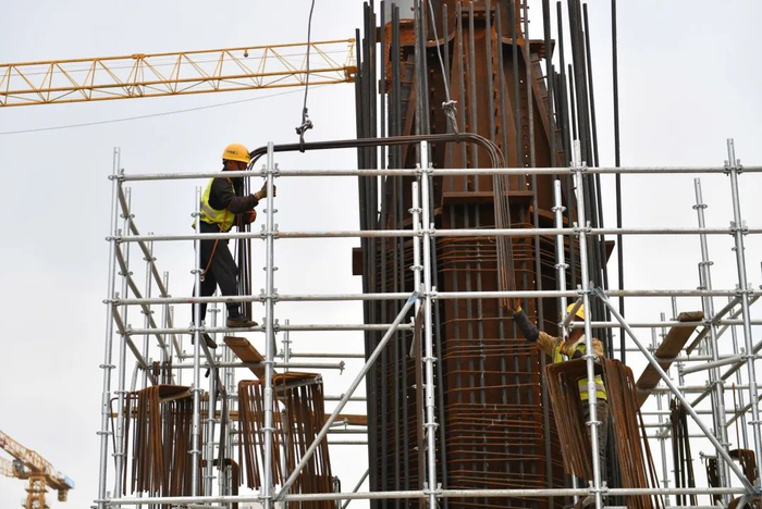 工人在进行承轨层结构柱钢筋绑扎。