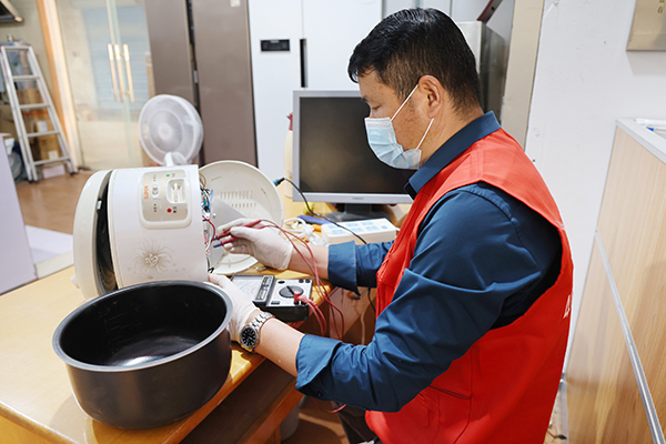 维修技师白和军修理电饭锅。 上海金山区供图