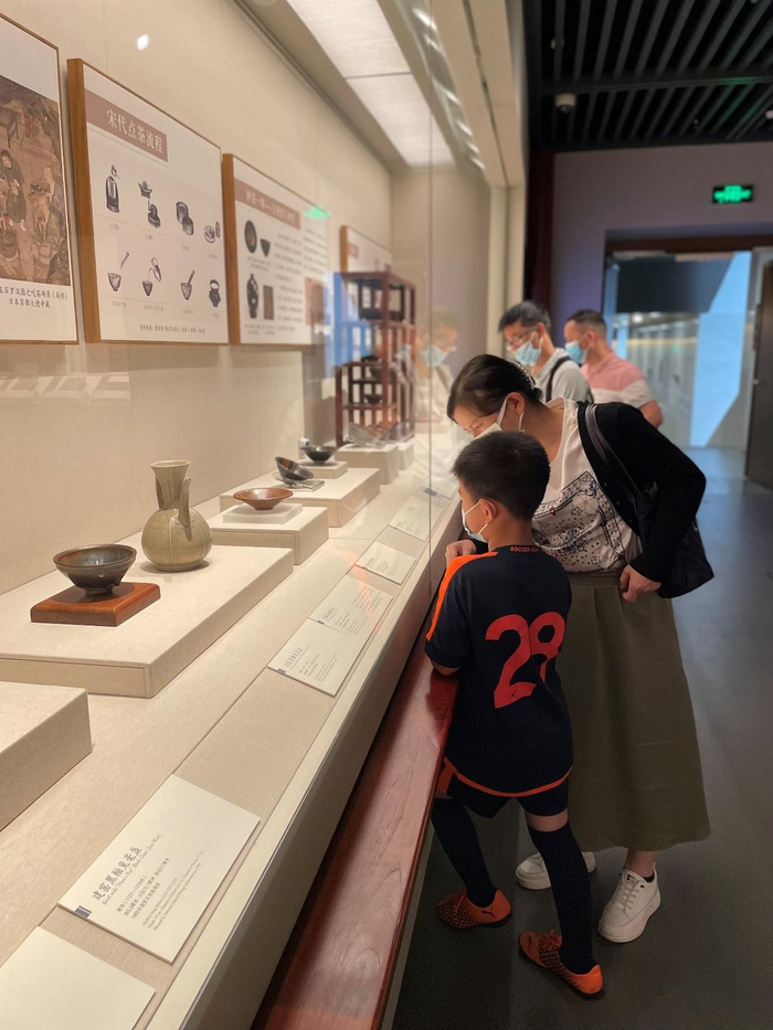 ▲5月15日，深圳博物馆古代艺术馆展厅内，一名参观者向孩子讲解展品。