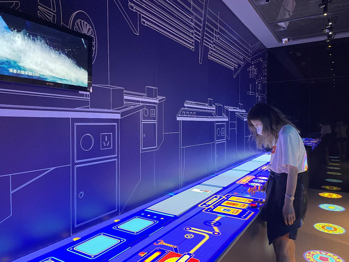 ▲5月15日，一名参观者在华强北博物馆参与手机DIY小游戏。 深圳晚报记者 余瑶 摄