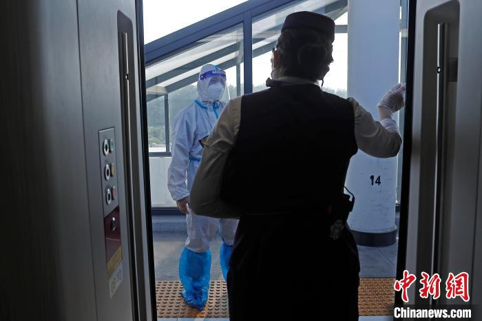 列车长沈乔与途径站台上的值班员交流。　殷立勤 摄