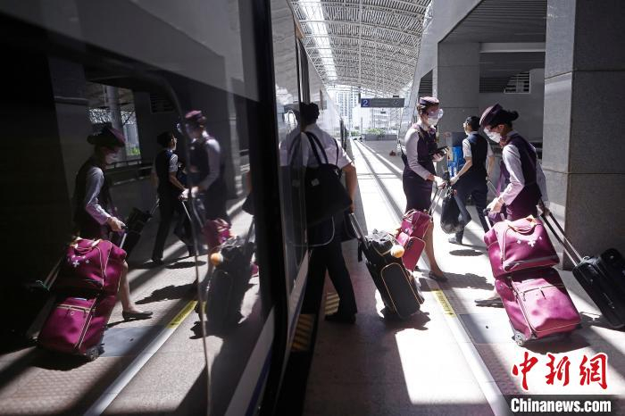 列车长沈乔和列车员有序上车。　殷立勤 摄