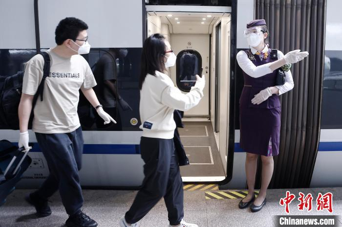 列车长沈乔引导旅客有序上车。　殷立勤 摄