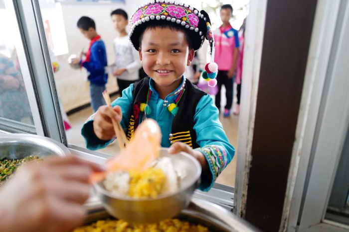 施甸县木老元乡的布朗族学生吃上可口的饭菜 陈飞 摄