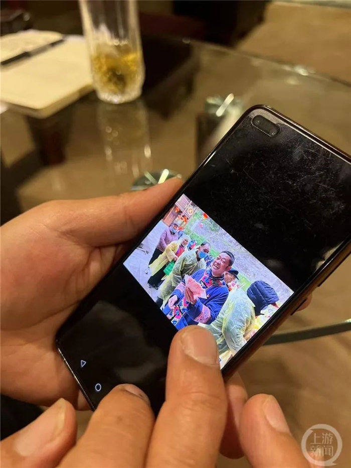 王祥生展示华溪村集体经济分红大会的照片。