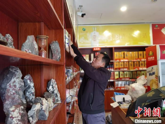 图为胡玉刚在店里整理商品。　周燕玲 摄