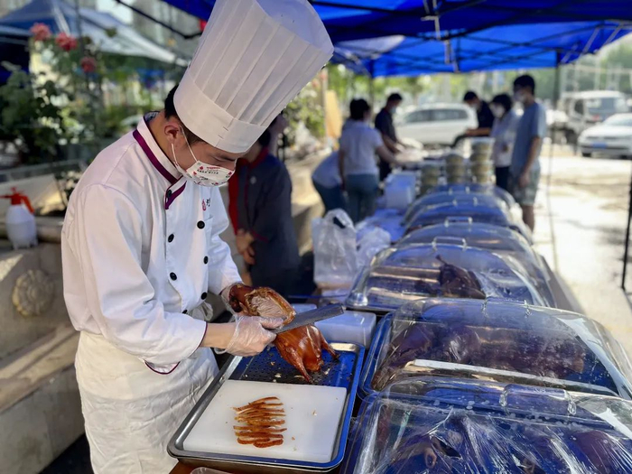 ▲5月24日傍晚，大鸭梨石佛营店迎来晚市高峰，厨师吴师傅在摊位片鸭。新京报记者 吴淋姝 摄