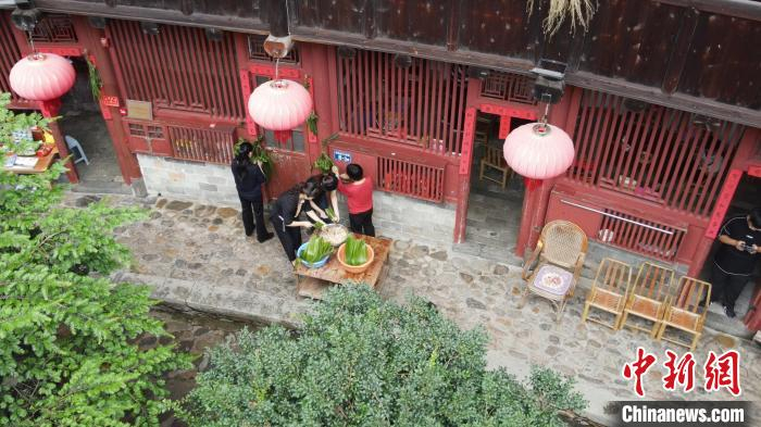 村民在土楼内忙着包粽子。　永定土楼景区供图
