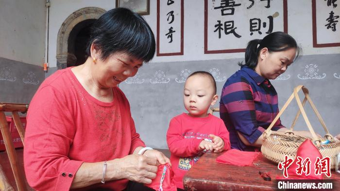 村民将艾草装进布包。　永定土楼景区供图