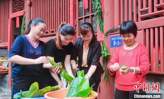 村民在土楼内忙着包粽子。　永定土楼景区供图