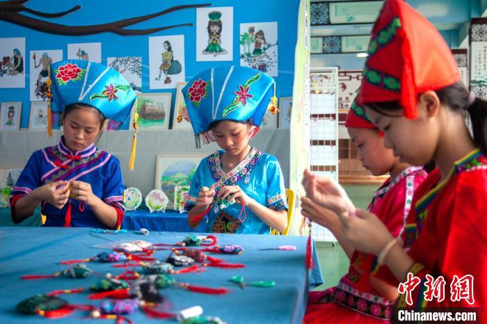 图为学生制作民族手工艺品。　陆建德 摄