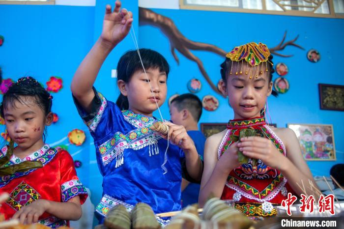 图为学生品民族特色美食。　陆建德 摄