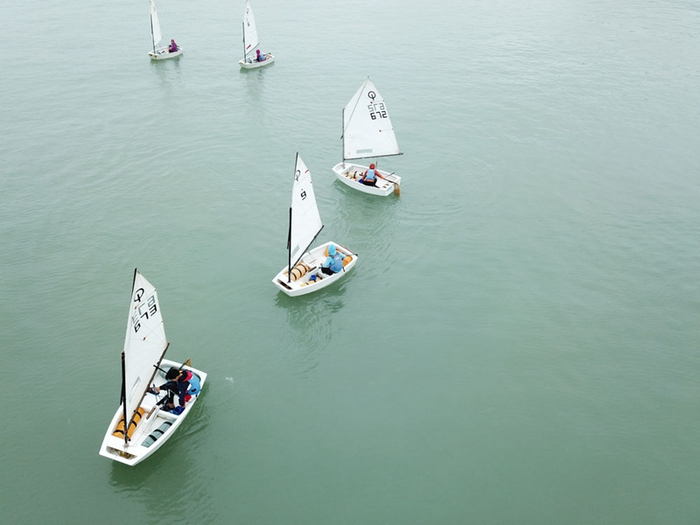 　↑2019年4月20日，浙江省台州市椒江区少体校大陈帆船帆板基地的孩子们在海上训练（无人机照片）。