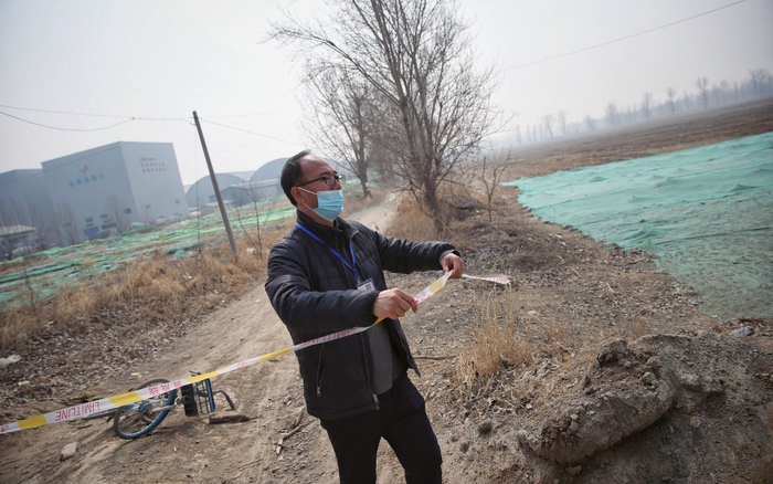 2022年3月10日，通州水南村，志愿者马德成重新拉起被扯断的警戒线，以防止汽车通过惊扰大鸨。新京报记者 薛珺 摄