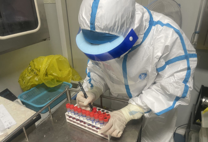 5月25日，在北京市上地医院核酸检测实验室，工作人员为核酸样本试管编号。新华社发