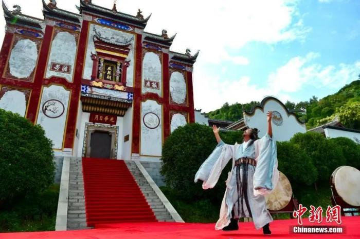 图为诗人着古装在屈原祠前吟诵诗作。中新社记者 刘康 摄