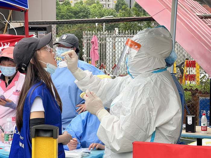 临时安置点里志愿者正在做核酸检测。