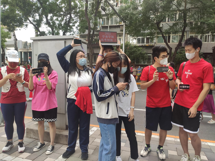 “高考加油团”在考场外为考生加油鼓劲。  新京报记者 吴苹苹 摄